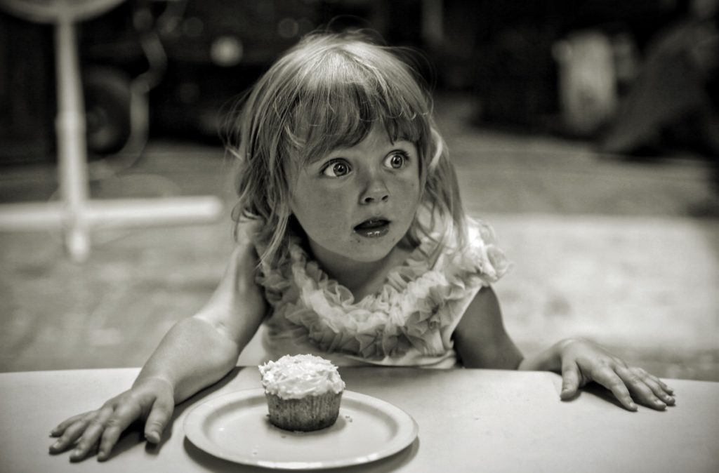 Little girl eating a cup cake